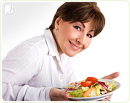 Woman with a salad: a healthy diet can prevent menopausal dizziness